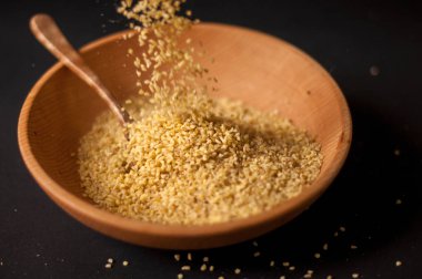 Koyu ahşap izole kahverengi ahşap kase kuru bulgur buğday