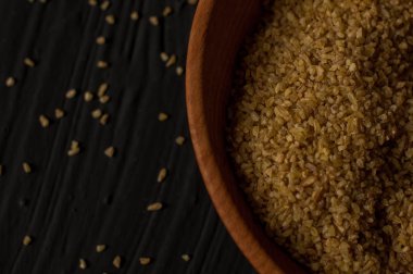 Koyu ahşap izole kahverengi ahşap kase kuru bulgur buğday