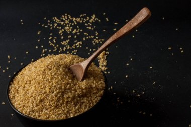 Koyu ahşap izole kahverengi ahşap kase kuru bulgur buğday