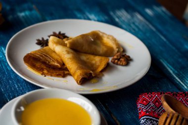 Krep beyaz tabakta bal şurubu ile. geleneksel krep krep hafta veya Shrovetide için. Krep ile kavrulmuş fındık