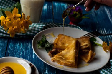 Krep beyaz tabakta bal şurubu ile. geleneksel krep krep hafta veya Shrovetide için. Krep ile kavrulmuş fındık