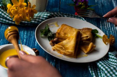 Krep beyaz tabakta bal şurubu ile. geleneksel krep krep hafta veya Shrovetide için. Krep ile kavrulmuş fındık