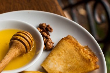 Krep beyaz tabakta bal şurubu ile. geleneksel krep krep hafta veya Shrovetide için. Krep ile kavrulmuş fındık