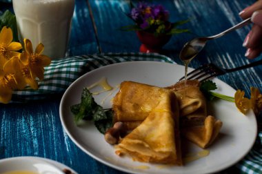 Krep beyaz tabakta bal şurubu ile. geleneksel krep krep hafta veya Shrovetide için. Krep ile kavrulmuş fındık
