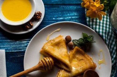 Krep beyaz tabakta bal şurubu ile. geleneksel krep krep hafta veya Shrovetide için. Krep ile kavrulmuş fındık