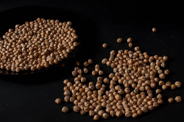 Grains de pois chiches crus dans un pot en bois sur fond de surface sombre — Photo