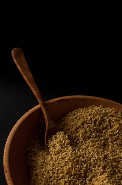 Koyu ahşap izole kahverengi ahşap kase kuru bulgur buğday