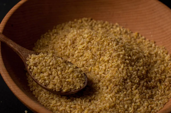 Koyu ahşap izole kahverengi ahşap kase kuru bulgur buğday