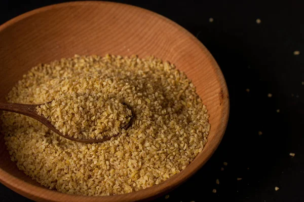 Koyu ahşap izole kahverengi ahşap kase kuru bulgur buğday