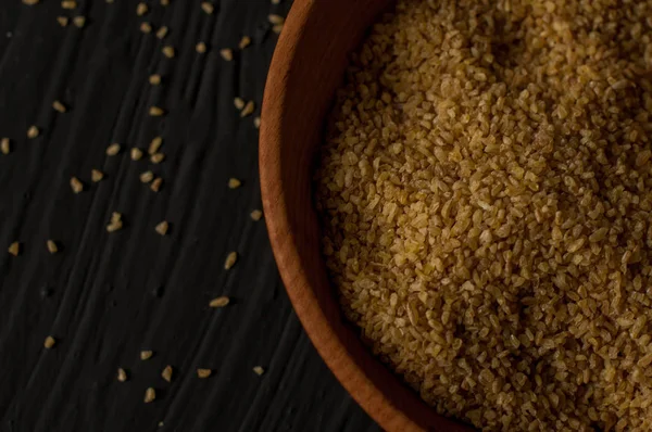 Koyu ahşap izole kahverengi ahşap kase kuru bulgur buğday