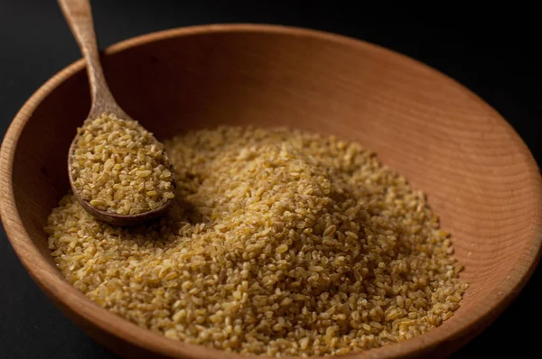 Koyu ahşap izole kahverengi ahşap kase kuru bulgur buğday