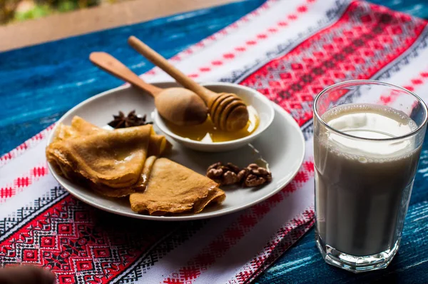 Krep beyaz tabakta bal şurubu ile. geleneksel krep krep hafta veya Shrovetide için. Krep ile kavrulmuş fındık