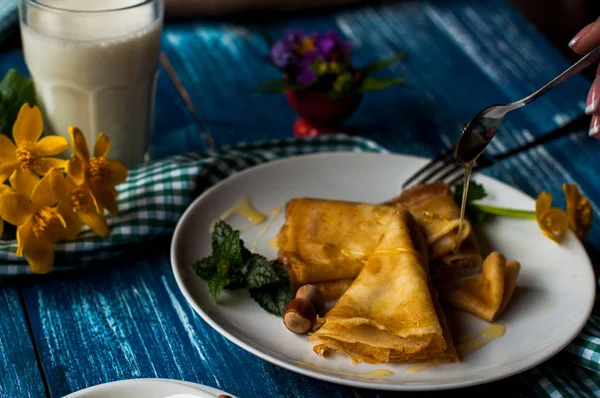 Krep beyaz tabakta bal şurubu ile. geleneksel krep krep hafta veya Shrovetide için. Krep ile kavrulmuş fındık