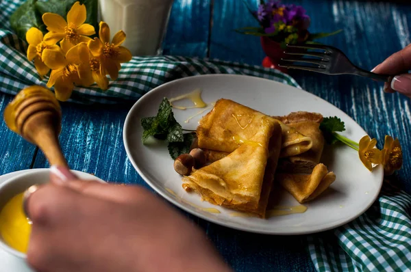 Krep beyaz tabakta bal şurubu ile. geleneksel krep krep hafta veya Shrovetide için. Krep ile kavrulmuş fındık