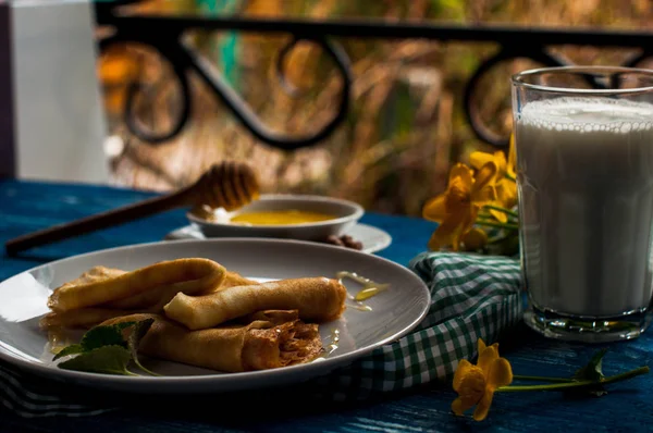 Krep beyaz tabakta bal şurubu ile. geleneksel krep krep hafta veya Shrovetide için. Krep ile kavrulmuş fındık