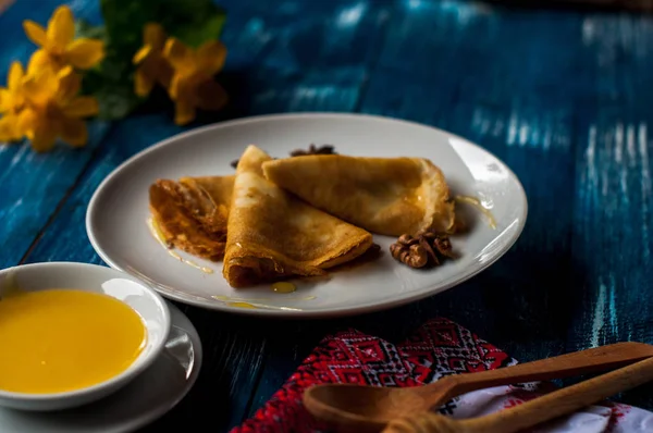 Krep beyaz tabakta bal şurubu ile. geleneksel krep krep hafta veya Shrovetide için. Krep ile kavrulmuş fındık