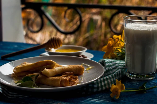 Krep beyaz tabakta bal şurubu ile. geleneksel krep krep hafta veya Shrovetide için. Krep ile kavrulmuş fındık