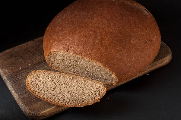 Bir somun ekmek yakın çekim karanlık bir arka plan — Stok fotoğraf