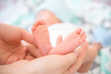 yeni doğmuş bebek ayakları yatakta