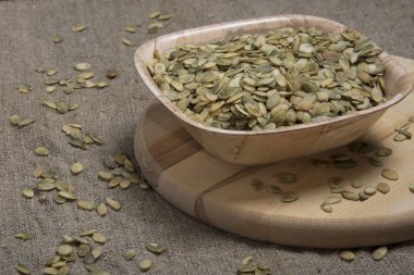 yuvarlak kesme tahtası üzerinde kabak çekirdeği ile kase