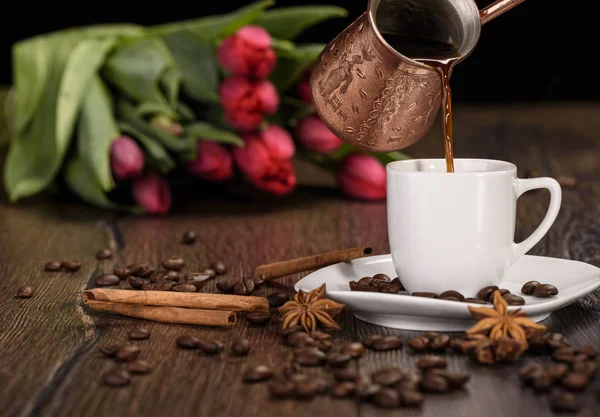 Menuang kopi dari teko kopi Turki melalui secangkir kopi — Stok Foto