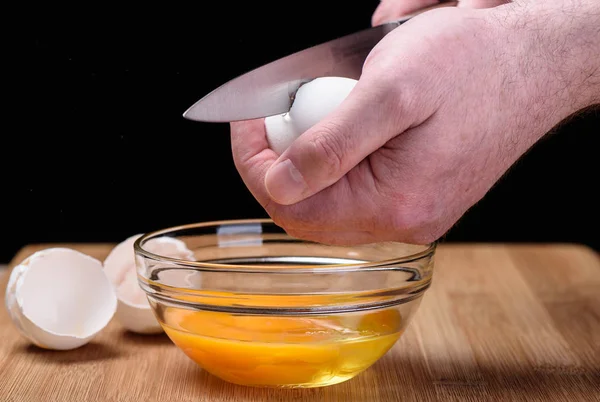 Разрушение куриного белого яйца ножом — стоковое фото