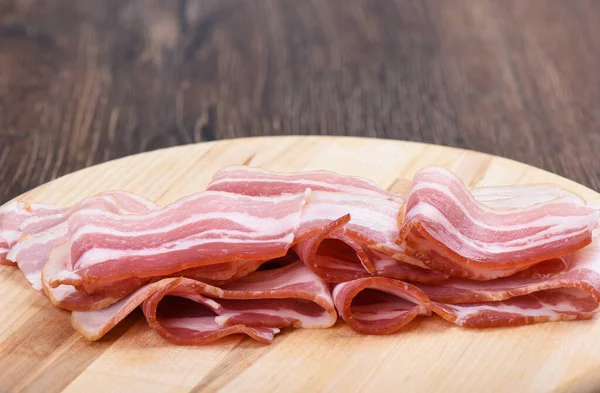 Rashers de bacon sur une planche à découper. Gros plan . — Photo