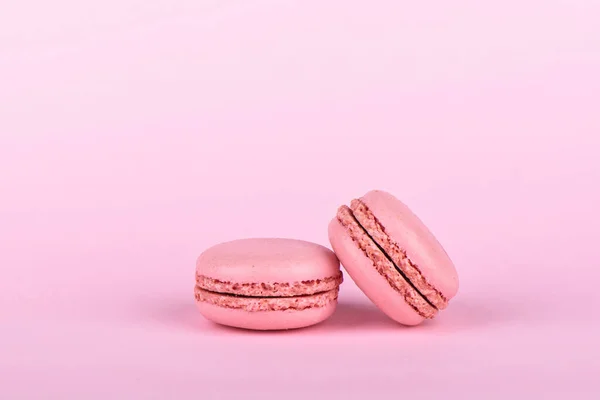 Két rózsaszín macaroons izolált rózsaszín alapon. — Stock Fotó