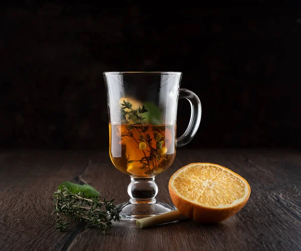 Caneca de vidro com chá de vitamina. Ingredientes de chá de vitamina em uma mesa de madeira . — Fotografia de Stock