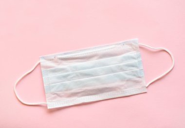 Pembe arka planda tıbbi koruyucu giysi. Toz ve bakteriden koruyucu giysi.