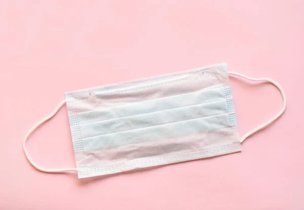 Pembe arka planda tıbbi koruyucu giysi. Toz ve bakteriden koruyucu giysi.