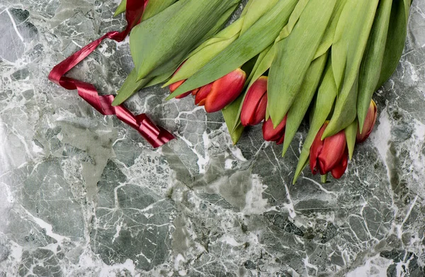 Friss vörös tulipán virágok piros szalaggal. — Stock Fotó