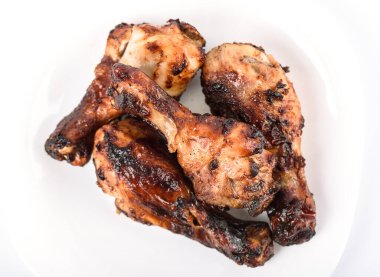 Soya sosunda marine edilmiş sulu ızgara tavuk budu. Diyet yemek. Beyaz arka planda beyaz bir tabakta tavuk budu. Üst görünüm.