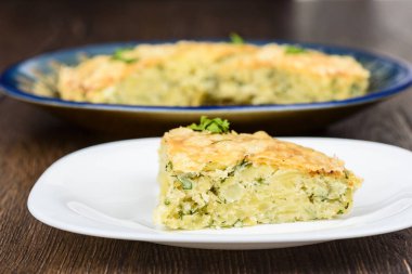 Beyaz tabakta peynirli bir dilim Türk beresi. Türk ulusal mutfağı. Ahşap arkaplan.