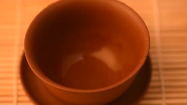 Despejando chá chinês verde em uma tigela de barro . — Vídeo de Stock