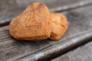 Şeker ve tarçın ahşap arka plan üzerinde kalp şeklinde ile ev yapımı kurabiye