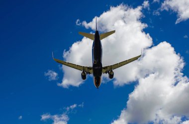 Arka plan mavi gökyüzü ve beyaz bulutlar uçakta.