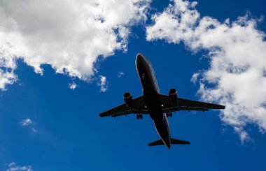Arka plan mavi gökyüzü ve beyaz bulutlar uçakta.