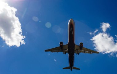 Arka plan mavi gökyüzü ve beyaz bulutlar uçakta.