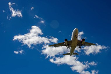 Arka plan mavi gökyüzü ve beyaz bulutlar uçakta.