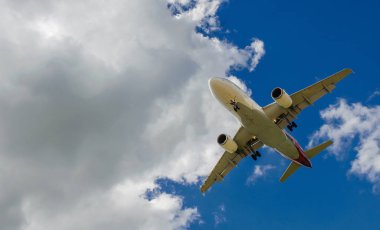 Arka plan mavi gökyüzü ve beyaz bulutlar uçakta.