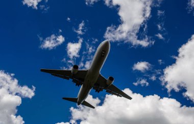 Arka plan mavi gökyüzü ve beyaz bulutlar uçakta.