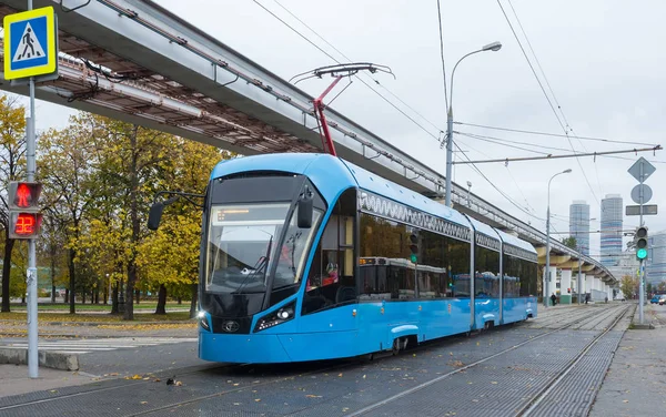 Cityscape zemin üzerine mavi elektrikli tramvay.