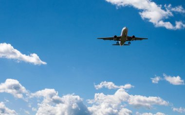 Arka plan mavi gökyüzü ve beyaz bulutlar uçakta.