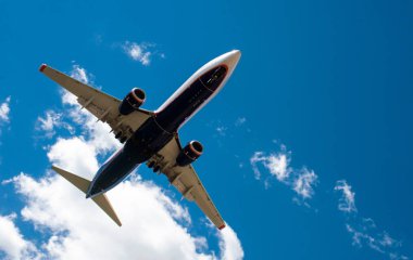 Arka plan mavi gökyüzü ve beyaz bulutlar uçakta.