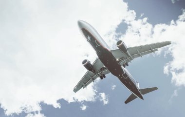 Arka plan mavi gökyüzü ve beyaz bulutlar uçakta.