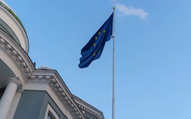 Avrupa Birliği mavi gökyüzüne karşı bayrak direği üzerinde resmi bayrağı.