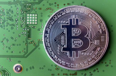 Gümüş Hediyelik eşya sikke Bitcoin bilgisayar devre kartı arka plan üzerinde.