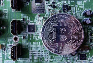 Gümüş Hediyelik eşya sikke Bitcoin bilgisayar devre kartı arka plan üzerinde.