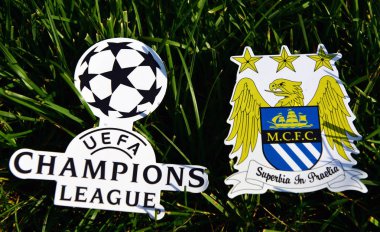 6 Eylül 2019 İstanbul, Türkiye. İngiliz futbol kulübü Manchester City 'nin amblemi, futbol sahasının yeşil çimlerinde Şampiyonlar Ligi logosunun yanında..